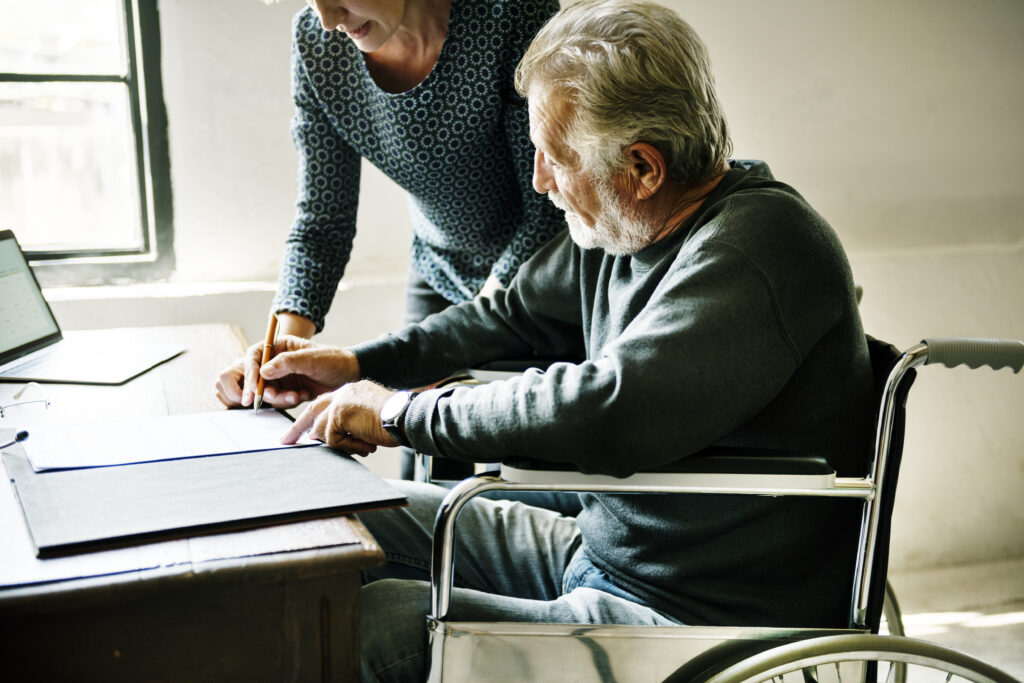 Side view of elderly man completing documents